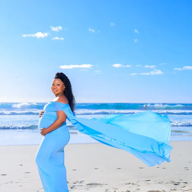Maternity session on the beach, gown flowing in the wind
