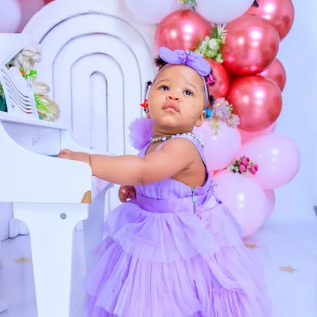 Baby's first birthday session at a toy piano, pink and rose-gold balloons