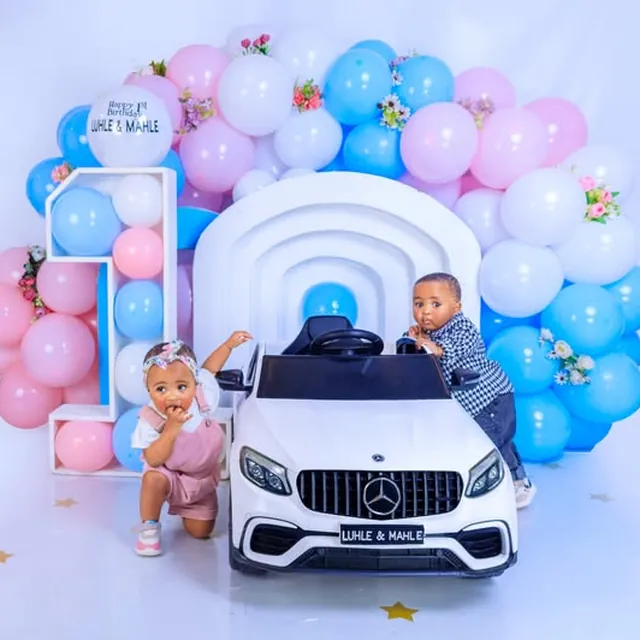 Twins' first birthday session on a toy Mercedes ride-on