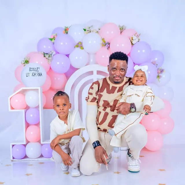 Father with his two children at a first birthday session, pastel balloon arch