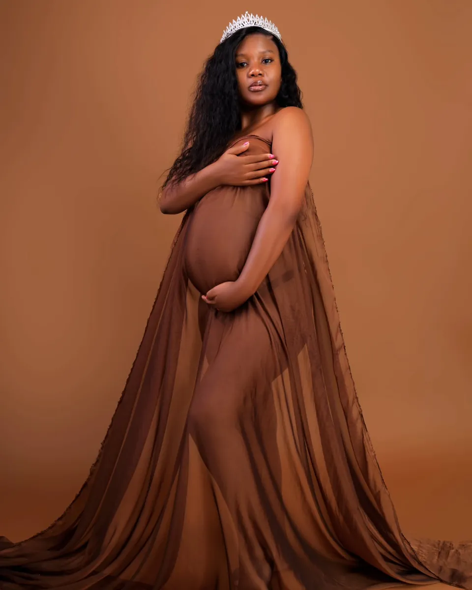 Maternity session, flowing brown gown against a warm studio backdrop